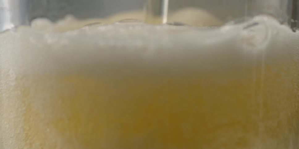 Liquid pouring and foaming into a glass