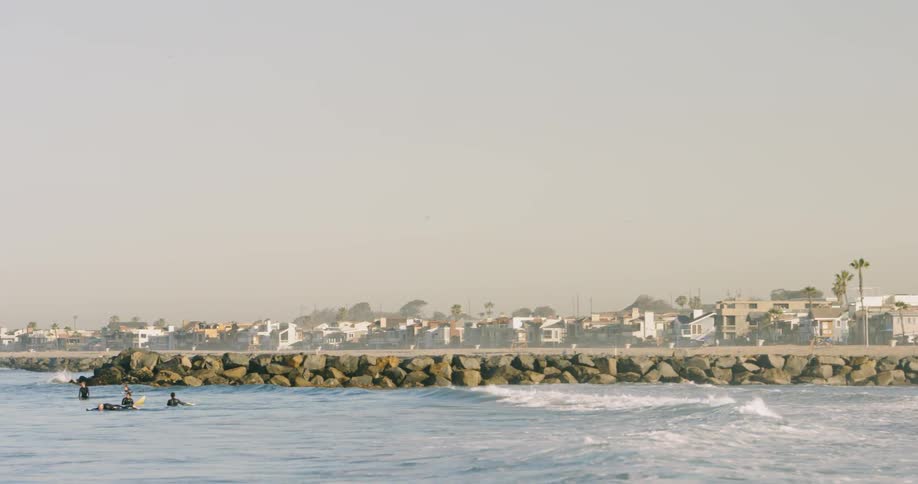 Surfers sitting on their boards while small waves come through