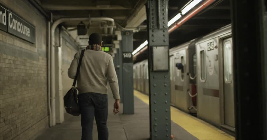 Someone with a duffel bag is walking through the subway