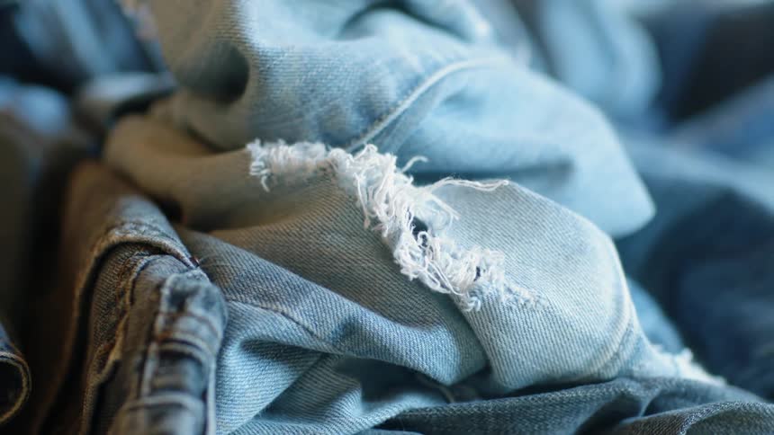Ripped denim sits in a pile