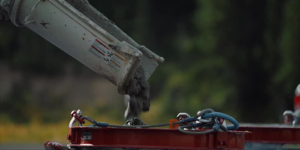 Cement is flowing from a truck into a bucket during the day