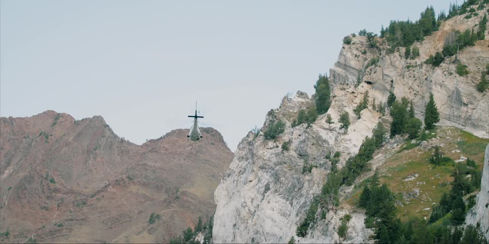 Helicopter flying low over rocky mountains