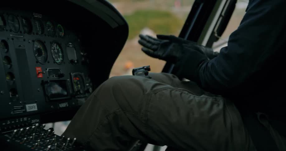 A helicopter pilot puts on gloves