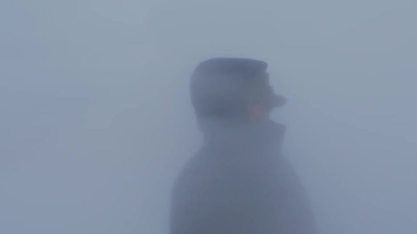 Person standing as heavy fog blows around