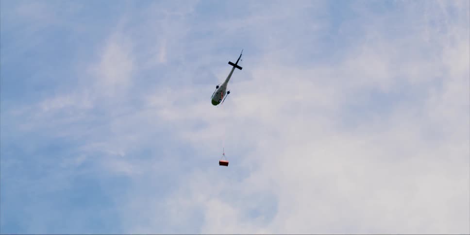 A helicopter passes by up high in the sky