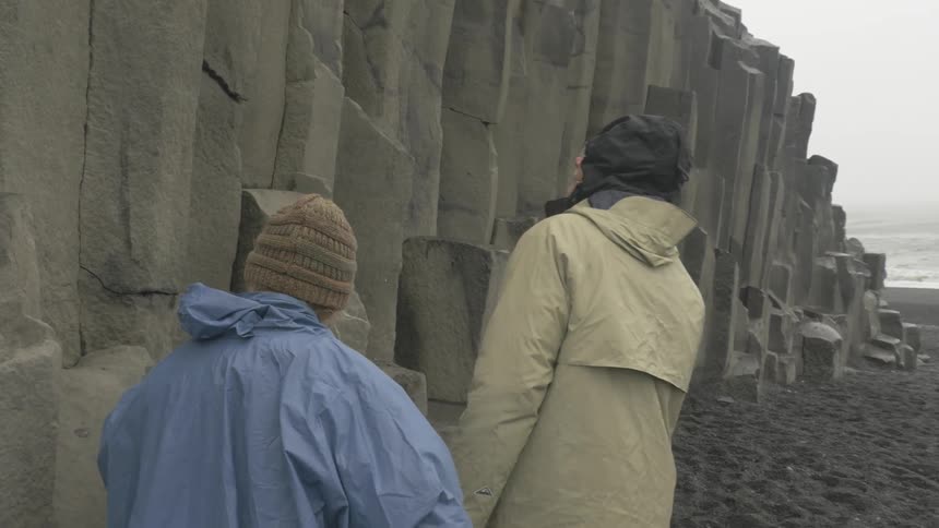 People walking next to a jagged cliff