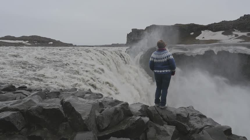 A person standing on the edge of a waterfall