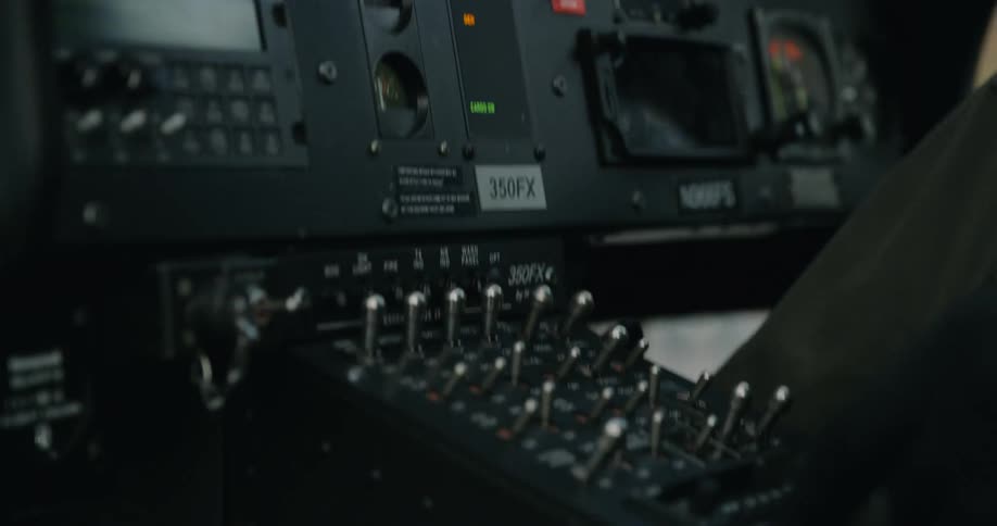 A pilot sets some controls on an airplane dash