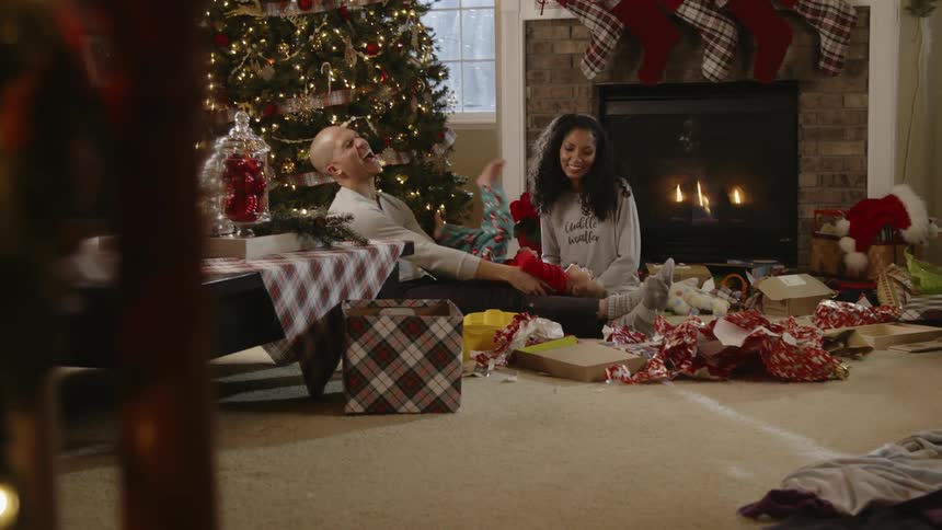 A family sits next to a christmas tree