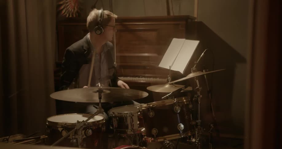 A man is playing the drums in a recording studio