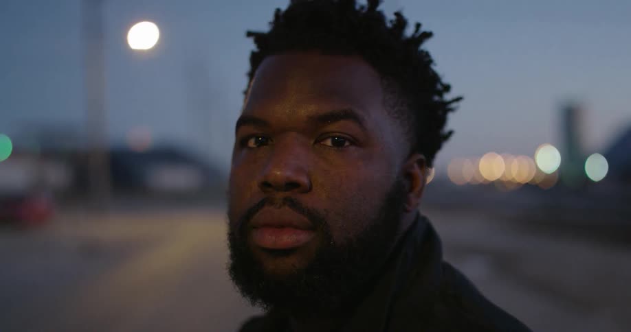 A man stands in a city at night