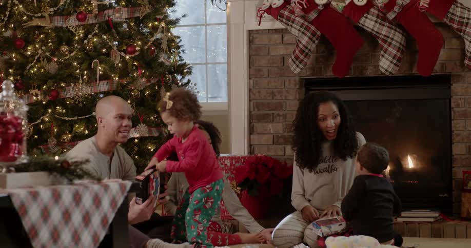 A family sits next to a christmas tree