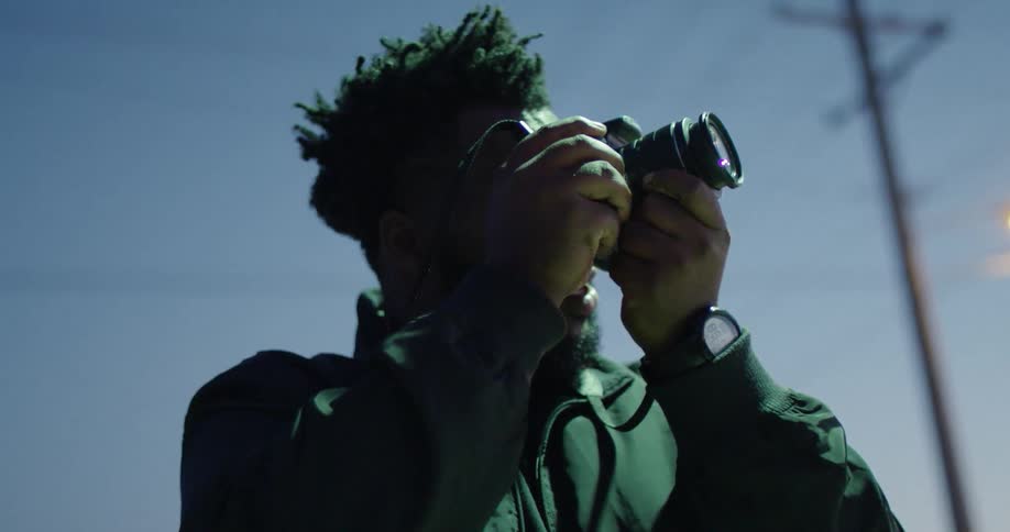A man takes a photograph on a sunny day