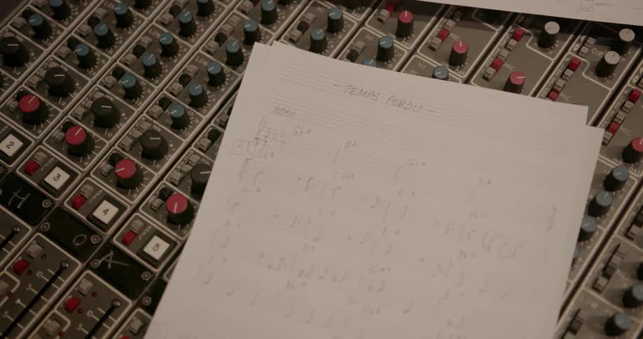 Music sheets sit on recording equipment
