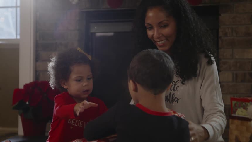 Mother and children open a christmas present