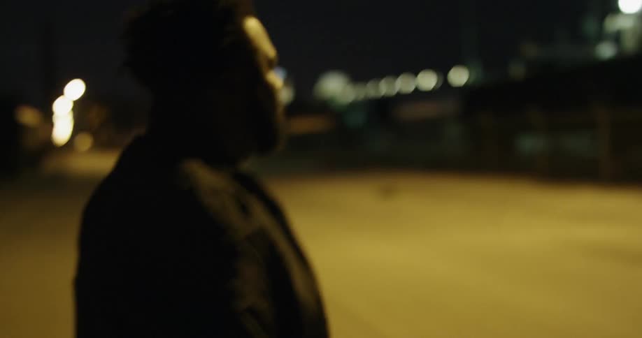 Man walks across a street at night