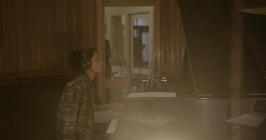 Woman plays a piano in a recording studio
