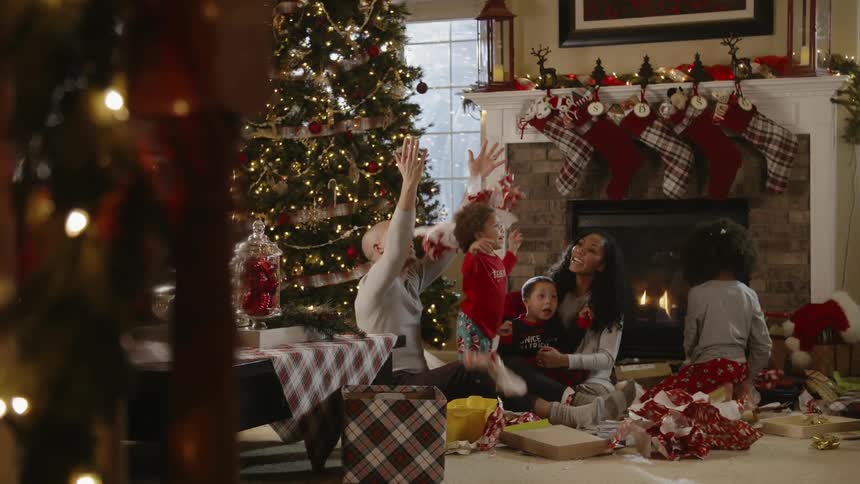 A family celebrate christmas while sitting on the floor