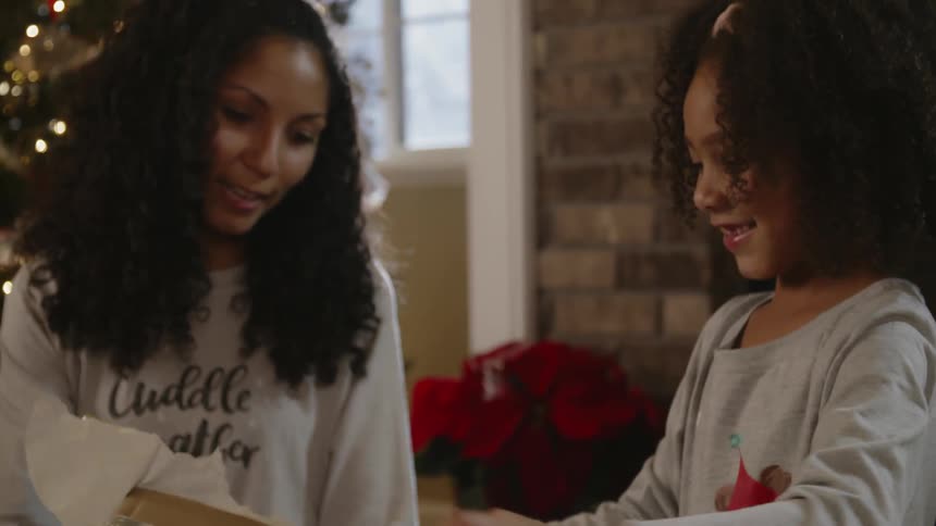A young girl opens christmas presents