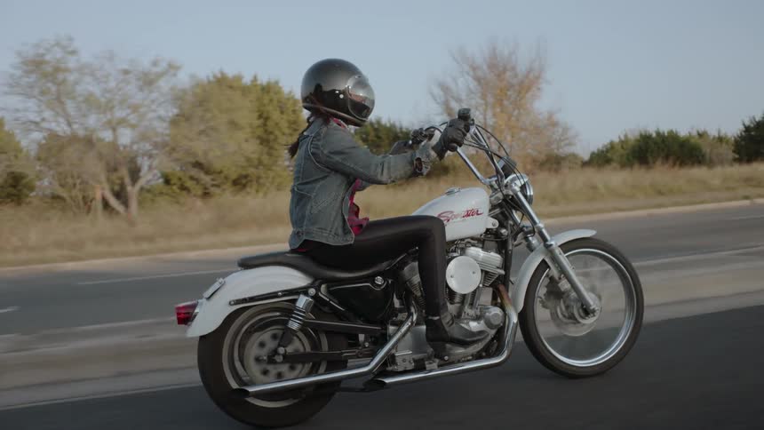 A motorcyclist rides on a rural road