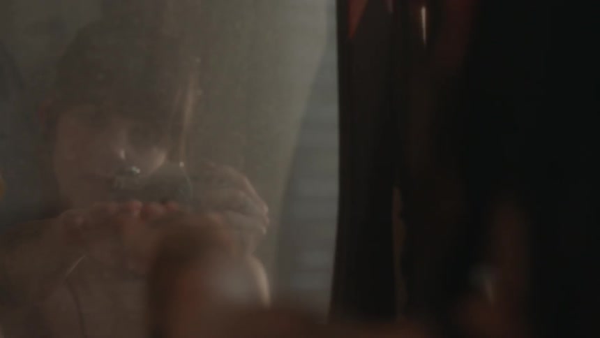 A woman reaches out towards a mirror
