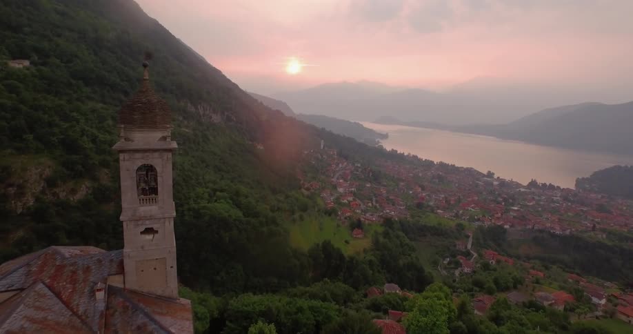 A church on a hilltop overlooking a village at sunset