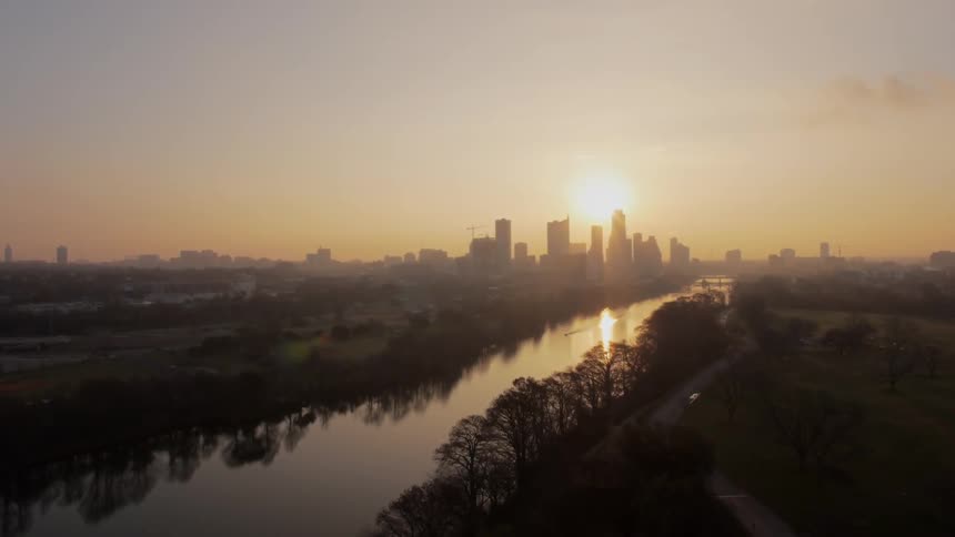 Sun rising over a city and a river
