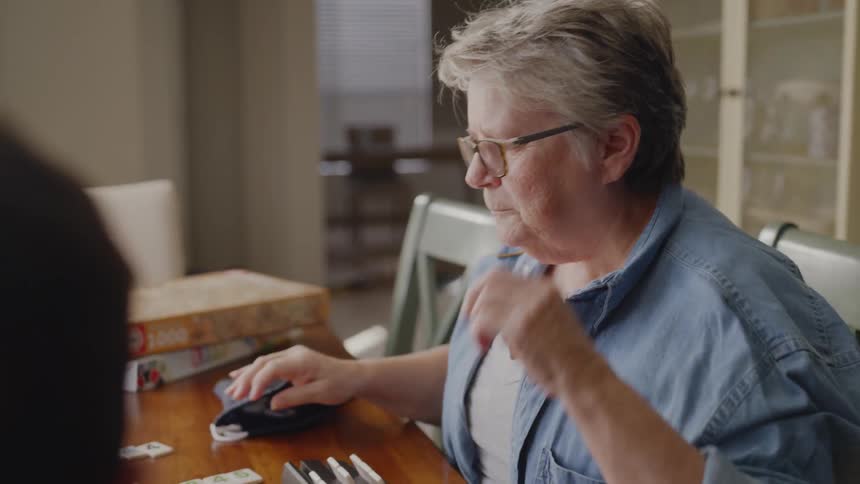 Elderly woman plays a table game with a boy