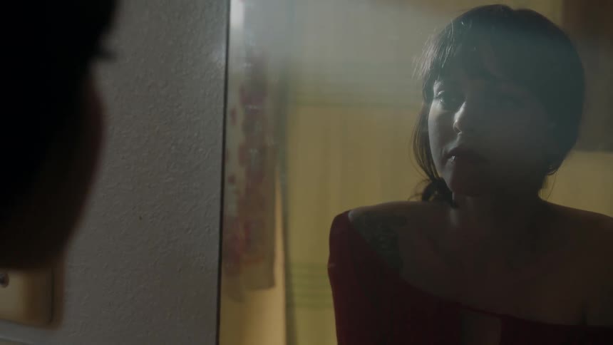 Woman stares into mirror and thinks