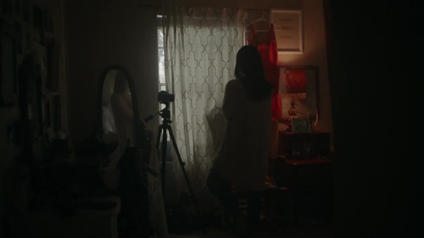 A woman stands in a dark room