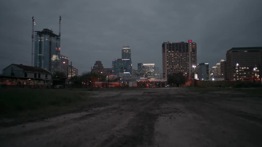 Dirt field outside a city at night