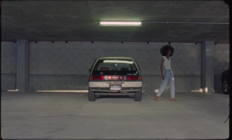 A woman exits a car in a parking garage