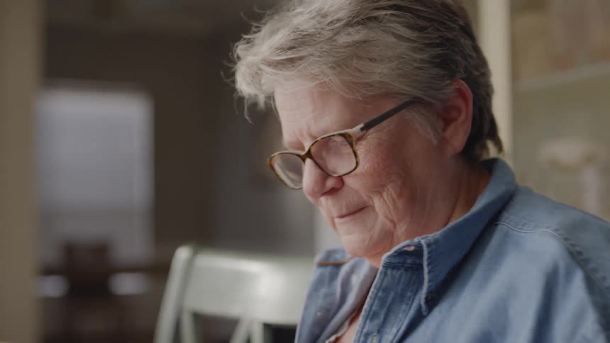 A woman is smiling and laughing as shes talking to someone