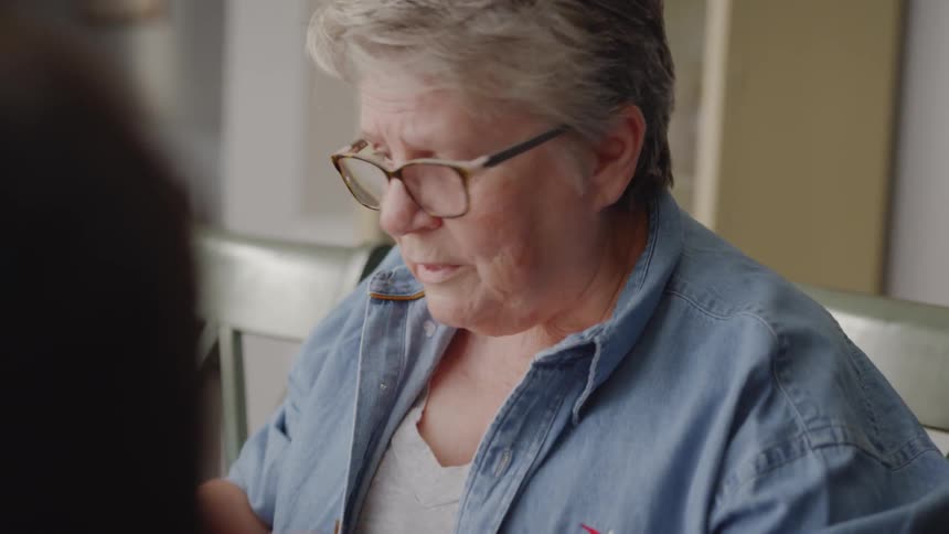 A woman gestures and talks as she plays a game with another person