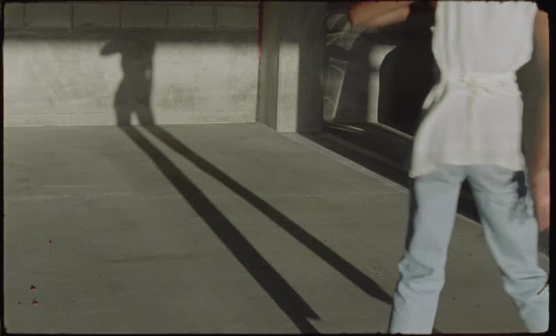 A woman is dancing next to her shadow