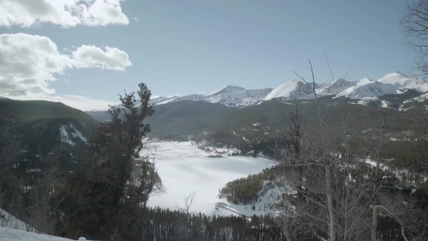 On a hillside overlooking a valley that's covered in snow