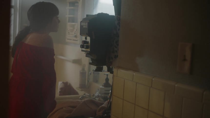 A woman looks in a bathroom mirror