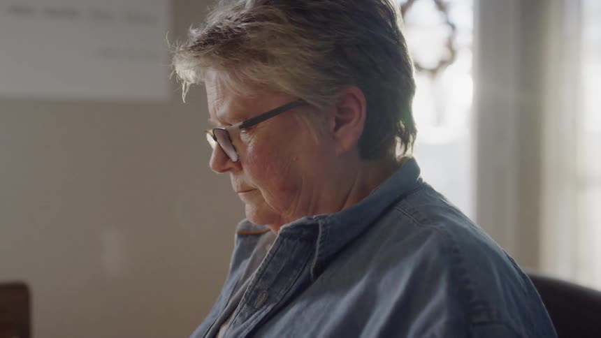 A woman wearing glasses sits at a table