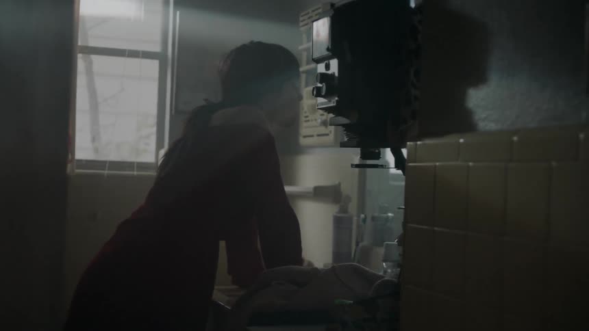 A woman looks into a bathroom mirror