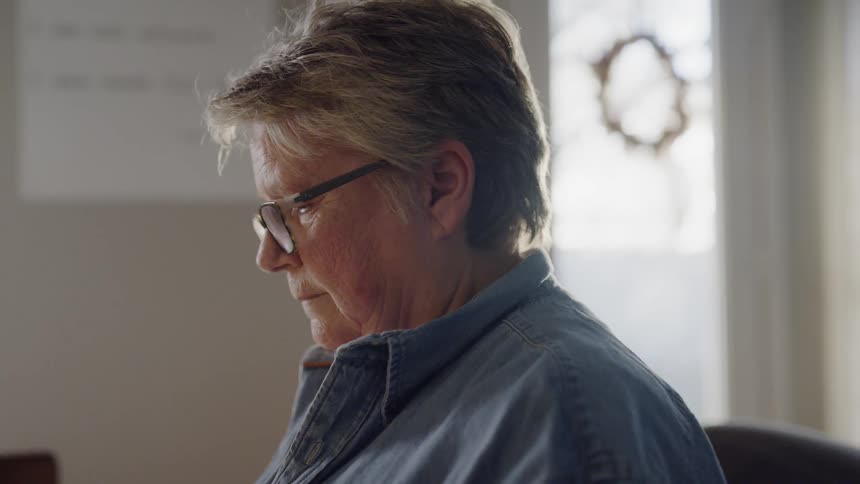 A woman sits in a sunny room
