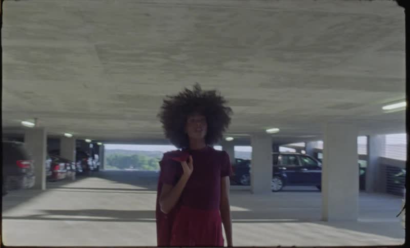A woman carrying a briefcase walks through a parking garage