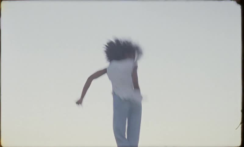 A woman jumps on a trampoline and kicks her legs out