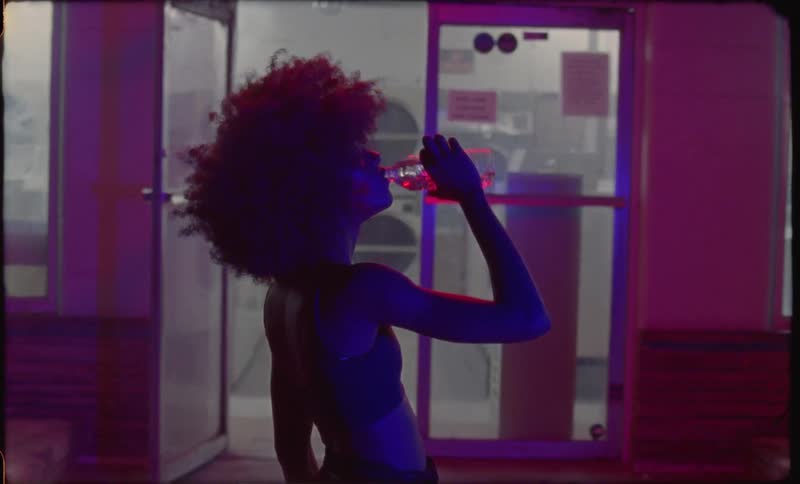 A woman takes a sip from a bottle outside