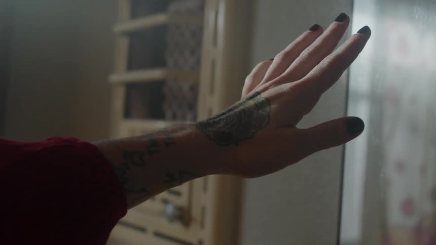 Woman stands in front of mirror and photographs herself with hand outreaching