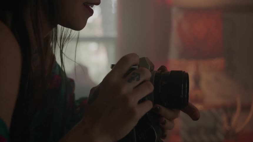 A woman takes a photograph indoors
