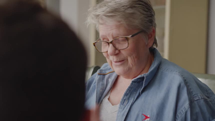 An older woman is talking to someone and asking them questions