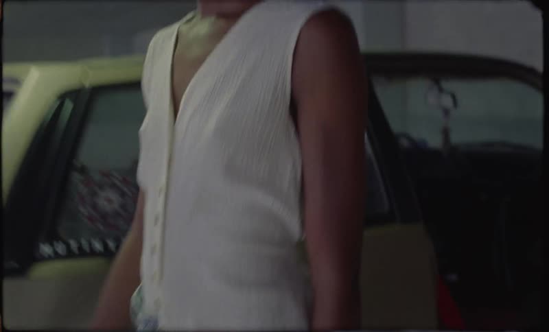 A woman is exiting a car in a parking garage and wandering off
