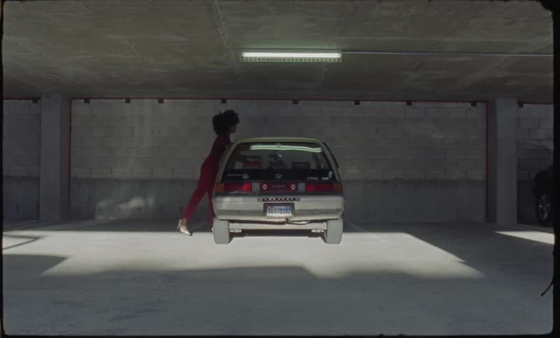 Person gets in a car parked in a carport