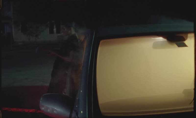 Person leans against smoke filled car putting out at lit match after lighting a cigarette
