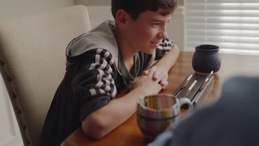 A boy playing a game picks up a game tile
